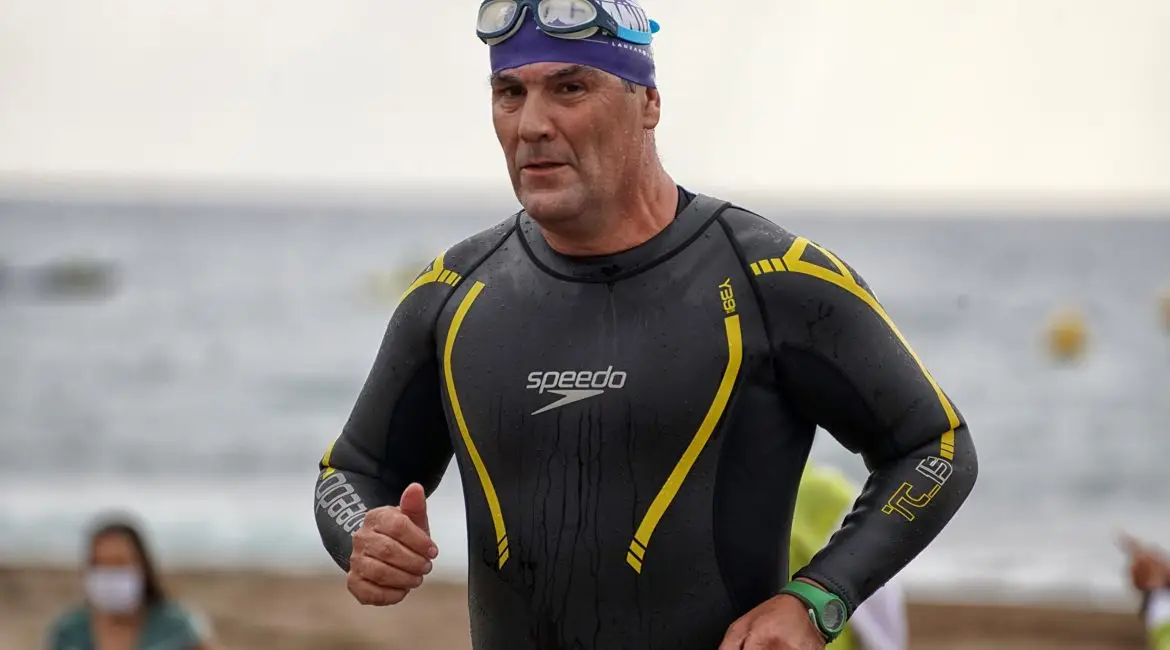 Older man getting out of the water at a triathlon