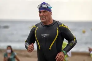 Older man getting out of the water at a triathlon